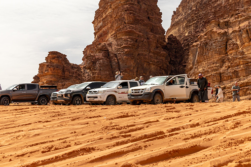 Wadi Rum, Jordan March 25, 2023  Four by four desert trucks on a sand dune with tourists.
