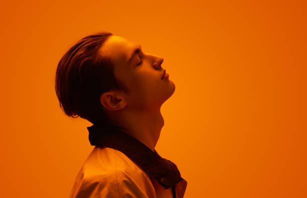 Teenager with closed eyes under neon light
