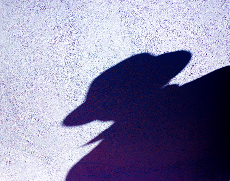 Ominous Silhouette Man in Fedora, White Wall