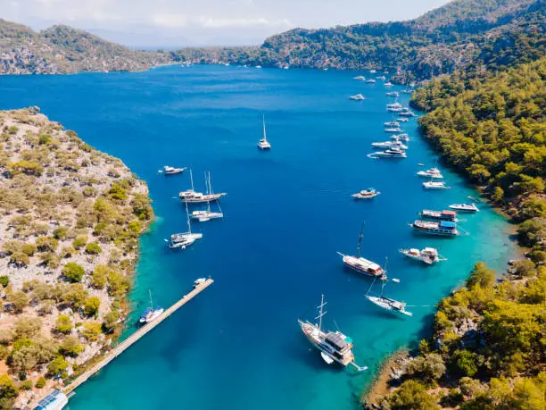 Photo of Aerial drone photo of Binlik Bay, located in the midst of Göcek and Dalaman, Fethiye. Daily tour boats and private yachts anchor to have serenity and enjoy the secluded bay.