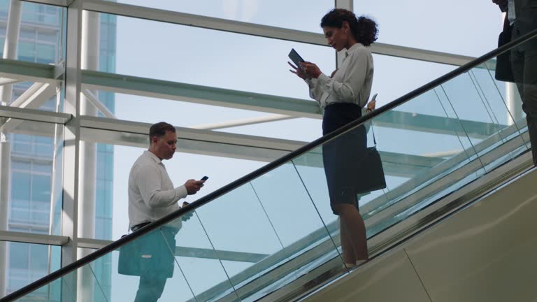 business people on escalators in busy corporate office lobby working nine to five rush 4k footage