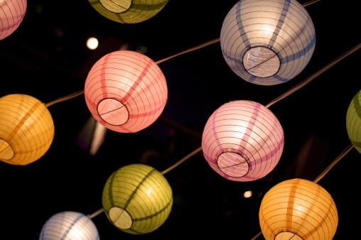 paper lanterns suspended from overhead on dark background