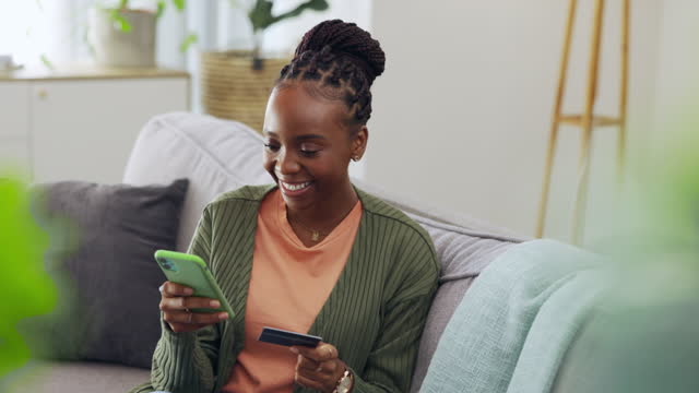 Credit card, online shopping and black woman with phone on a sofa for ecommerce, payment or banking at home. Debit, fintech and girl with internet subscription, membership or budget in living room