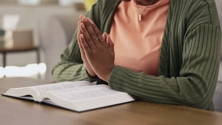 Black woman, hands and praying, worship with Bible and Christian, faith and spiritual, gratitude and hope in religion. Religious scripture, trust and female in prayer with respect, holy book and God