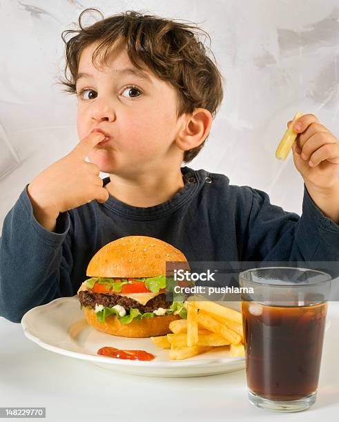 Young Boy Comer Chessburger Foto de stock y más banco de imágenes de Niño - Niño, Comer, Hamburguesa - Alimento