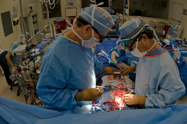 Two doctors operating a heart bypass patient  stock photo
