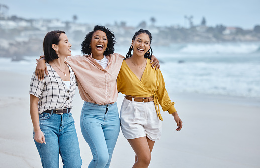 Diversity, friends and beach, hug and walk while laughing, relax and talking against nature background. Travel, women and group embrace while walking at the sea, happy and smile on ocean trip in Bali