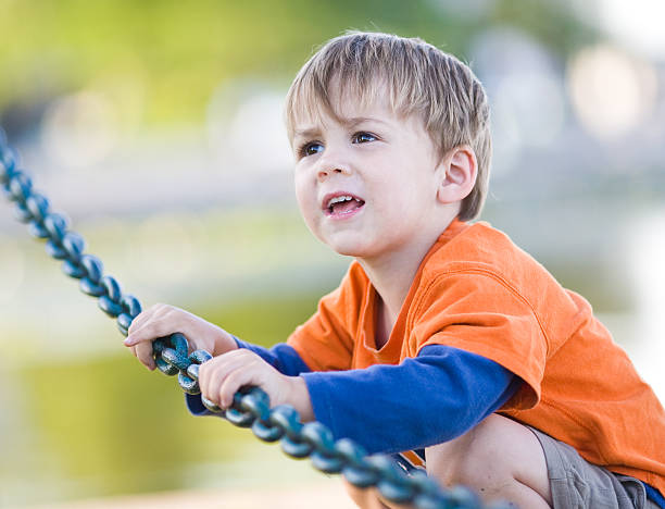 Cute child holding onto a chain stock photo