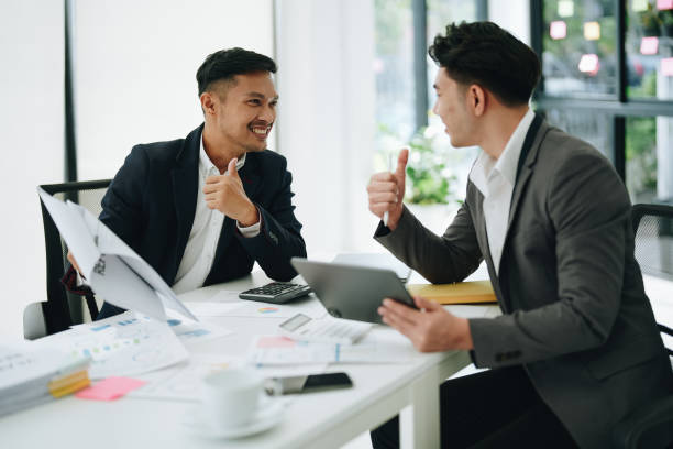 istock Two business men meeting to talking or discuss marketing work in workplace using paperwork, calculator, computer to work. 1482307826