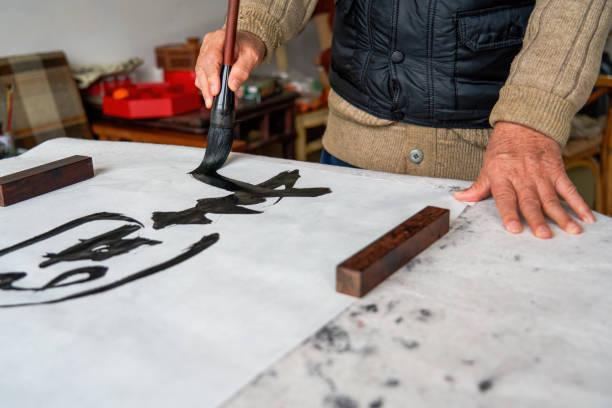 istock An old Chinese calligrapher is creating and writing calligraphy works.Translation: carry on the past and open up the future. 1482310284
