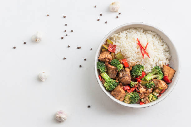 istock Stir fried chicken and broccoli bell pepper has rice in bowl on white wood table. 1482313793