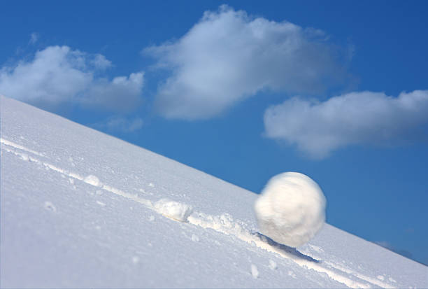 Snow ball Snow ball slides downhill and speeds up. perpetual motion stock pictures, royalty-free photos & images