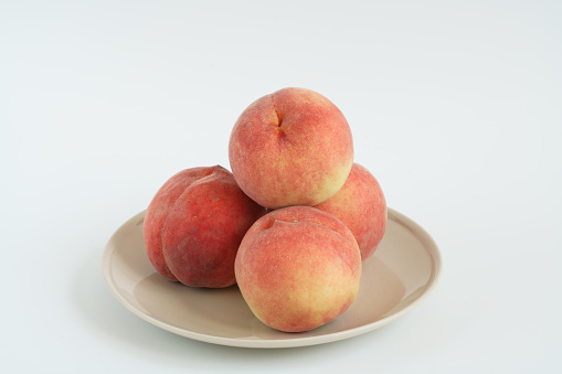 Ripe juicy peach in the woman's hands on the grey table. Space for text.