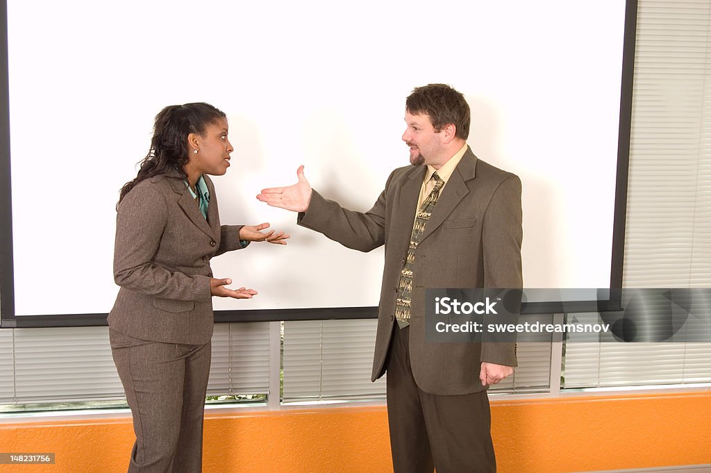 Afro-americana donna d'affari e caucasico Uomo d'affari Litigare - Foto stock royalty-free di Affranto