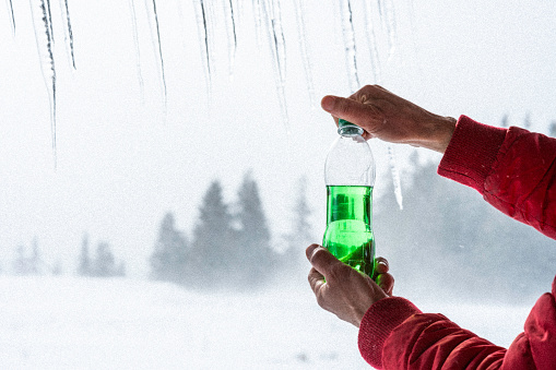 Beverage in bottle on the background of snowy landscape.