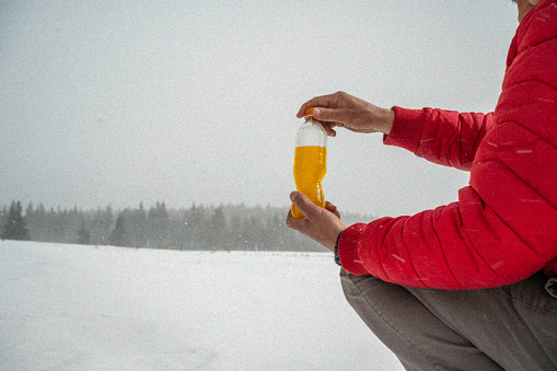 Beverage in bottle on the background of snowy landscape.