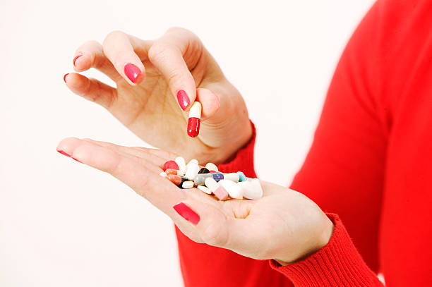istock Hand holding pills and capsules with one selected 148232457