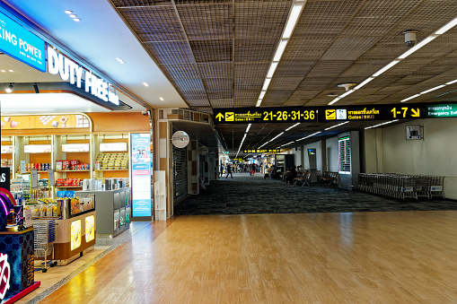 Bangkok, Thailand - March 21, 2023: The departure terminal of Don Mueang International Airport, with the  duty free shop is in the foreground and the departure gate in the background.