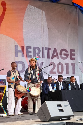Johannesburg, South Africa – February 01, 2023: A vibrant outdoor stage at the Heritage Day 2011 event in South Africa, with people playing traditional drums