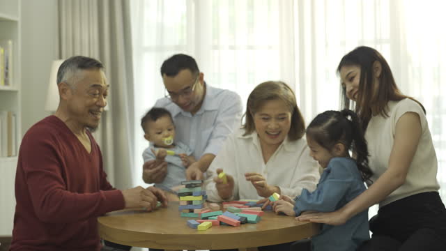 Multi-Generation Family Playing Wooden Block In A Living Room