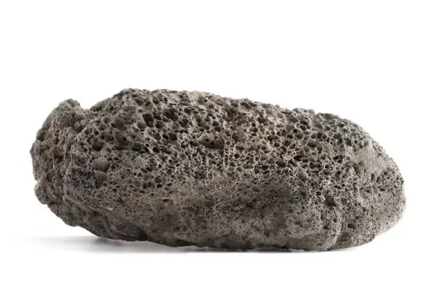 Dark rough basalt rocks on white background. Isolated. Front view.