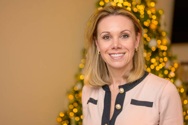 istock Middle-aged woman standing in front of Christmas tree 1482334556