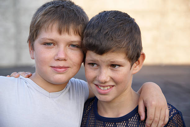 Two happy brothers hugging each other's necks on a sunny day in Tennessee.