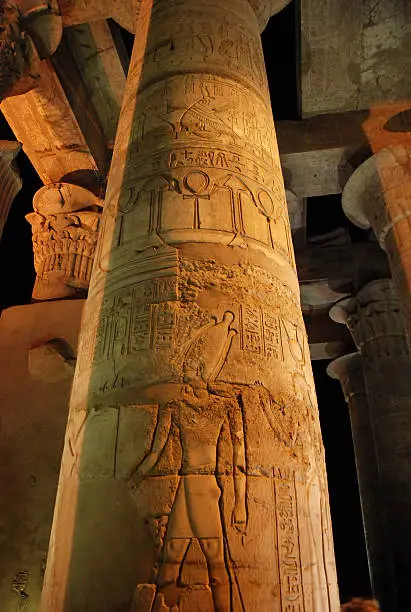 Close view of a column with many carvings. Artificially illuminated. The temple of Kom-Ombo, Egypt.