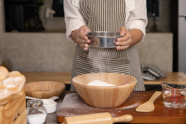 istock Woman Hand Sifting Bread Flour Before the Process of Kneading Dough 1482337175