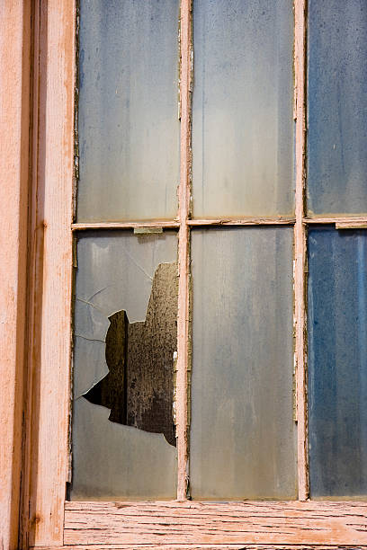 Vertical image of broken window in an abandoned building stock photo
