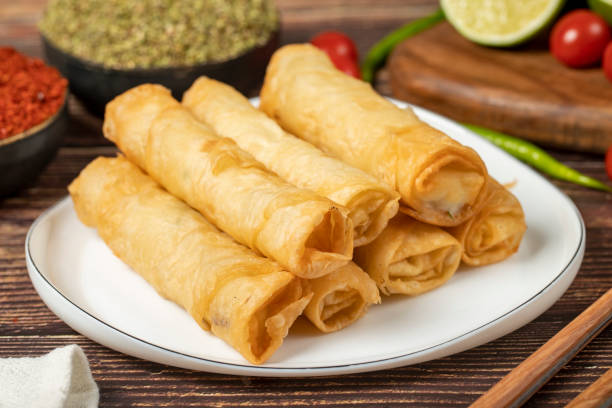 istock Cigarette pastry. Cheese pie on wood floor. Fried cheese rolls with phyllo. Local name sigara boregi. Close up 1482339867