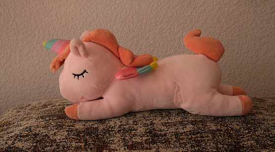 Sleeping on a pillow unicorn toy.