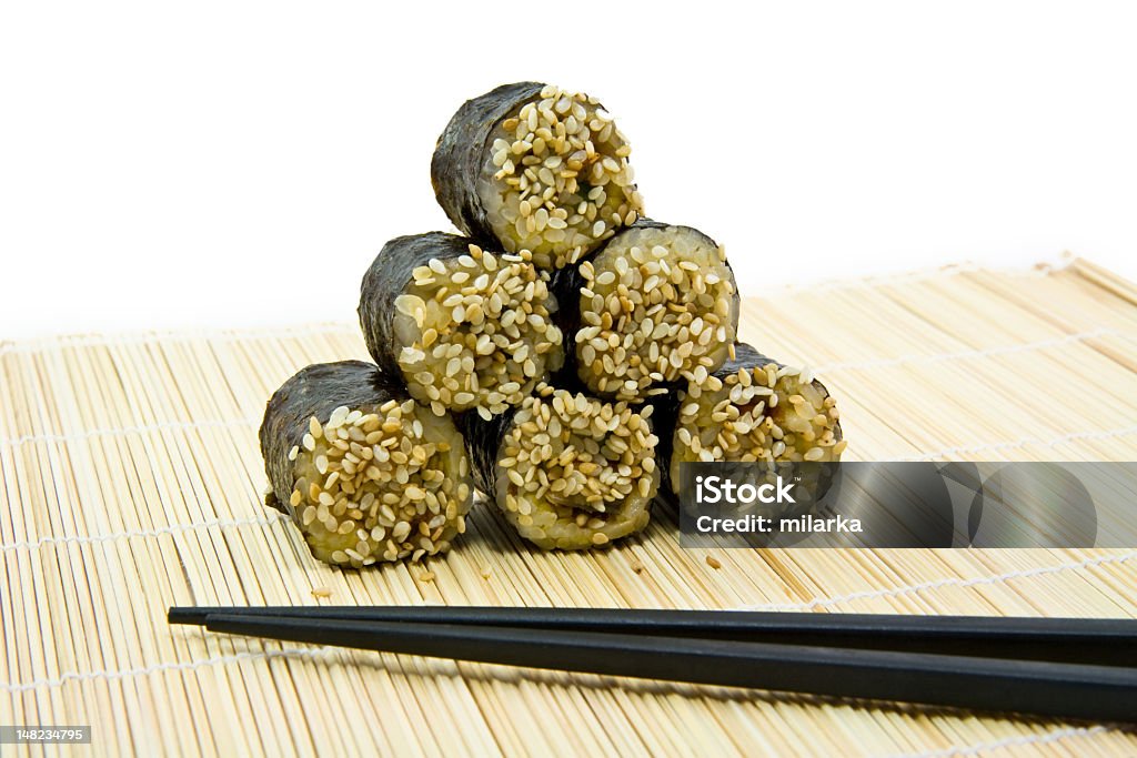 Japanese rolls with sesame and sticks Japanese rolls with sesame and sticks on the mat Appetizer Stock Photo