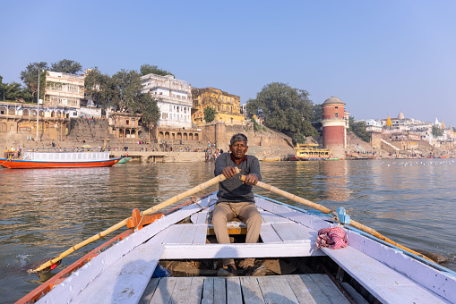 Varanasi, Uttar Pradesh, India - November 2022: Tourists enjoying boat ride in the river ganges along with the herd of sea gulls at varanasi during early morning.