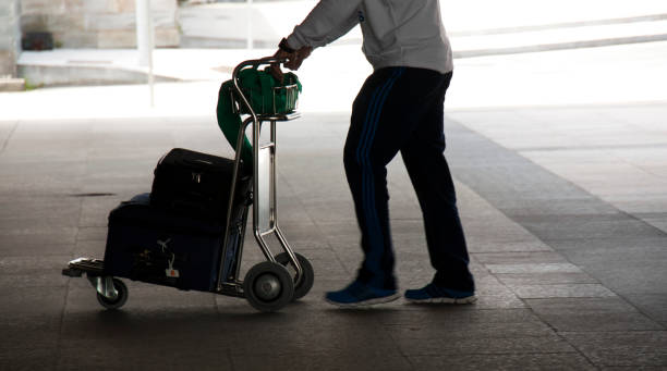 Man pushing luggage cart. A Coruña airport, Galicia, Spain.