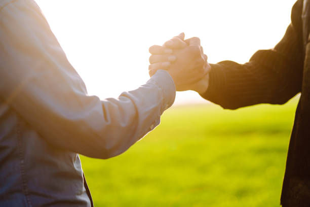 cropped view of father and teenager son shaking hands