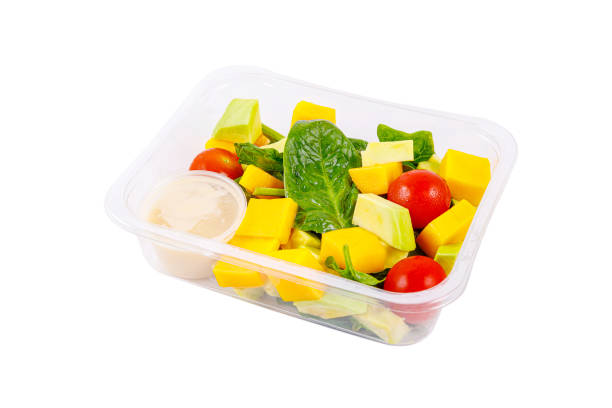 istock Fresh salad of avocado, mango, spinach and cherry tomatoes in a plastic container on a white background. 1482358208