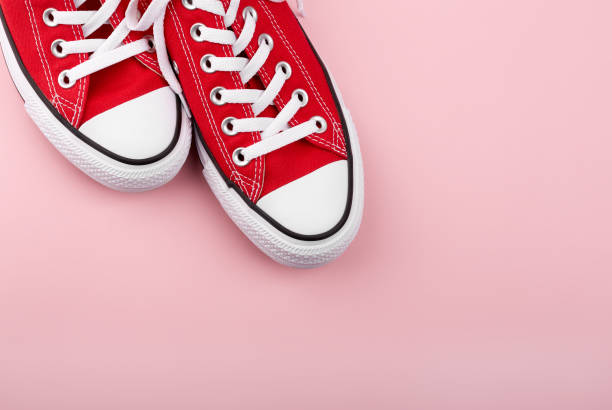istock Red sneakers on pink background with copy space. Youth shoes. 1482371810