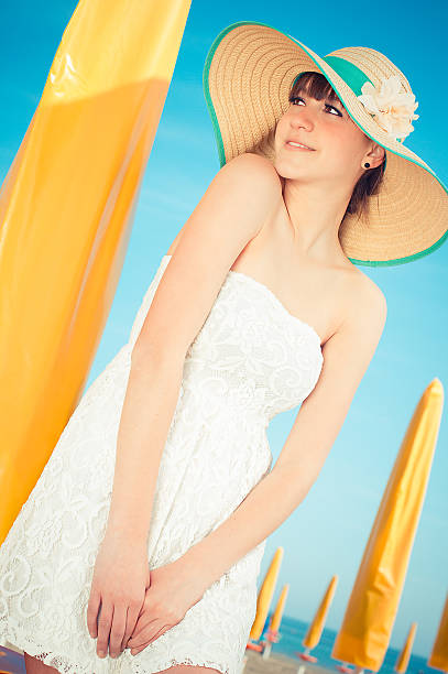 Girl on a beach with hat stock photo