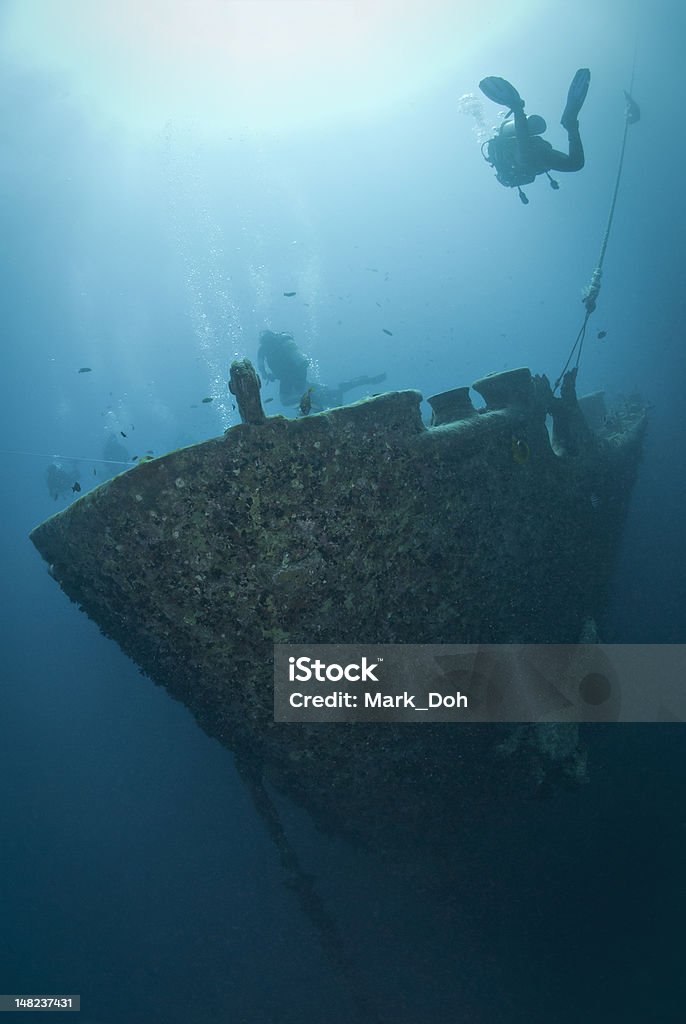 Silhouettes of scuba divers exploring a shipwreck. Silhouettes of scuba divers exploring the bow of the SS Thistlegorm shipwreck. SS Thistlegorm, Straights of Gubal, Red Sea, Egypt. Undersea Stock Photo