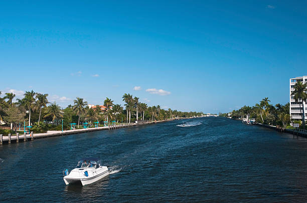 Boat on intracoastal waterway, Delray Beach, Florida A boat travelling on the intracoastal waterway in Delray Beach, Florida, with a jet ski in the background. In the distance is a bridge across the waterway. delray beach fl stock pictures, royalty-free photos & images
