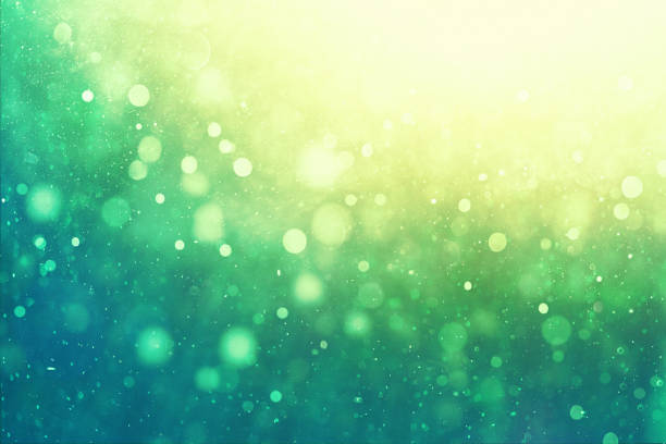 Defocused green background with floating particles stock photo