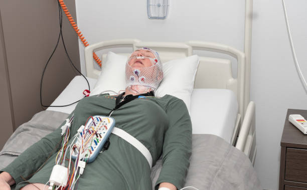 istock Middle aged woman measuring brain waves, examining polysomnography in sleep lab 1482377143