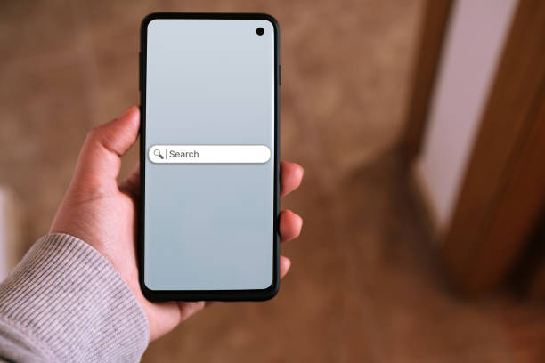 istock Woman using smartphone with search bar on screen. 1482378084
