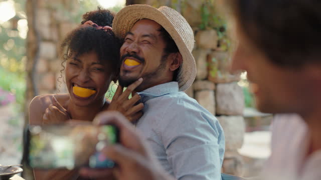 funny couple eating oranges posing for photo making faces having fun with friends laughing enjoying summer reunion outdoors happy tourist people on vacation 4k
