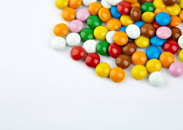 istock colorful candy on white background. Rainbow sprinkles for topping ice cream and cake. Small candies in colored chocolate glaze. 1482381268