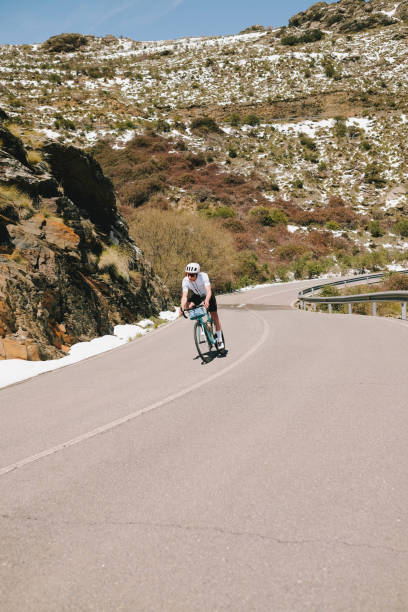 istock Road cyclist rides up snowy mountain road 1482384879