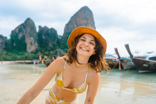 Young Caucasian cheerful woman having fun  on Railey beach in Krabi