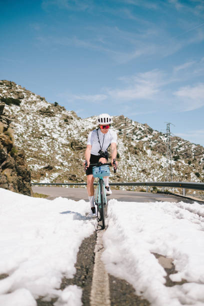 istock Road cyclist rides dividing line on mountain road 1482384981