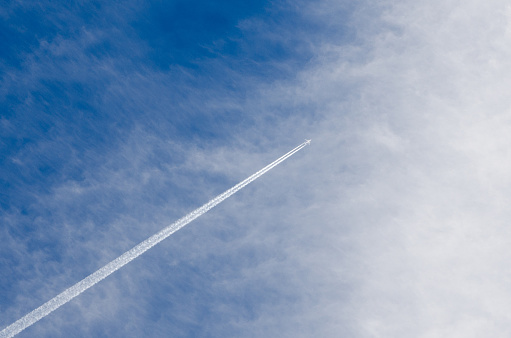 Airplane leaving a white trace in the sky